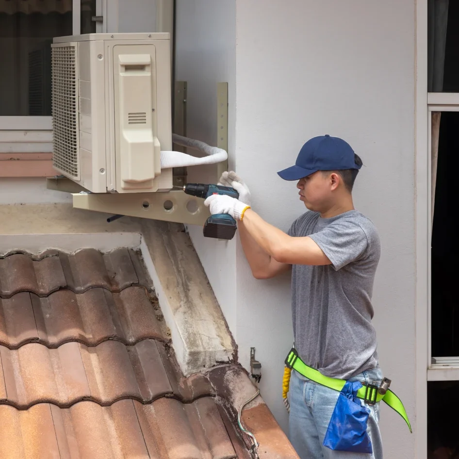 Technician installing outdoor air conditioning unit